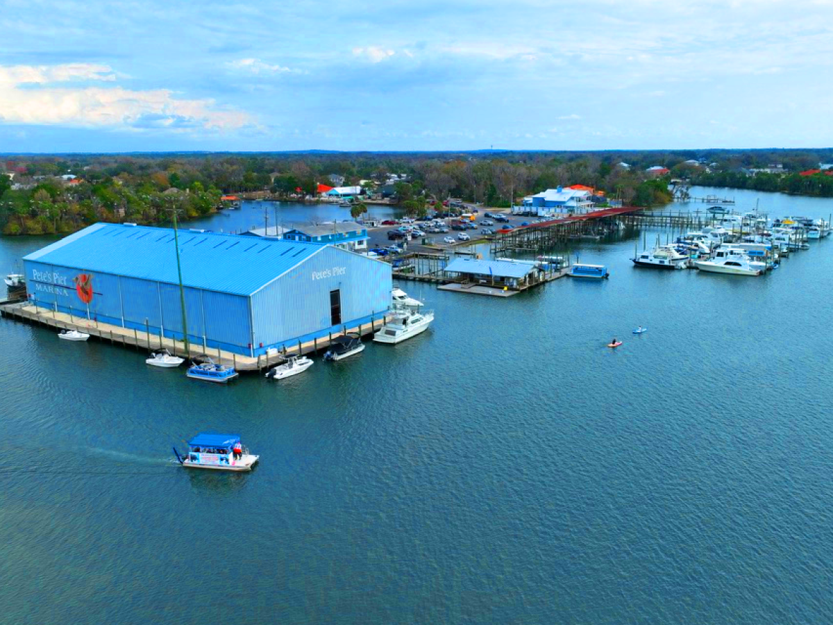 Aerial view of a marina with boats and a large blue building labeled 'Pete's Pier'.